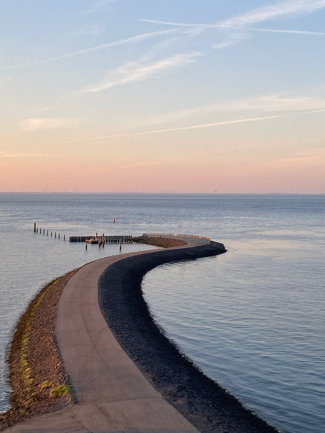 Gebogener Weg durch ruhiges Wasser bei Sonnenuntergang